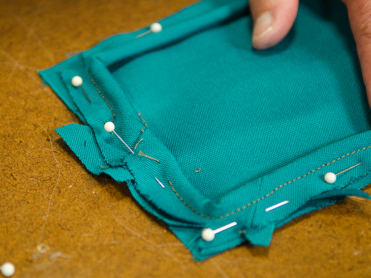 Fold the angled fabric over to create a clean piping junction